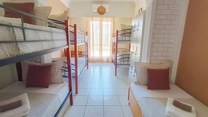A dormitory room with bunk beds, a tiled floor, and a window with sheer curtains. - 4-bedroom Athens Smart Stay - Base Rate - Extra Customisable (Athens)
