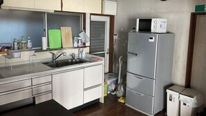 Une cuisine de taille réduite équipée d’un évier, d’un four à micro-ondes et d’un réfrigérateur.