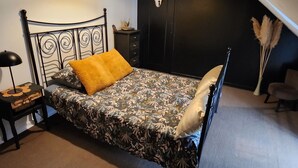 A bedroom with a bed, a nightstand, a dresser, a black door, and a hanging light fixture. - 3-bedroom apartment, 2 steps from Chambord, Loire castles, Beauval (Tour-en-Sologne)