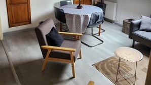 A cozy loft-style room with a dining table, a sofa, and a small side table. - 3-bedroom apartment, 2 steps from Chambord, Loire castles, Beauval (Tour-en-Sologne)