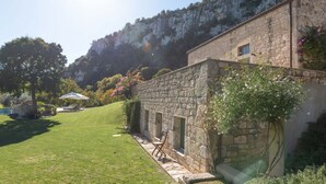 A stone building with a small garden and a pool.
