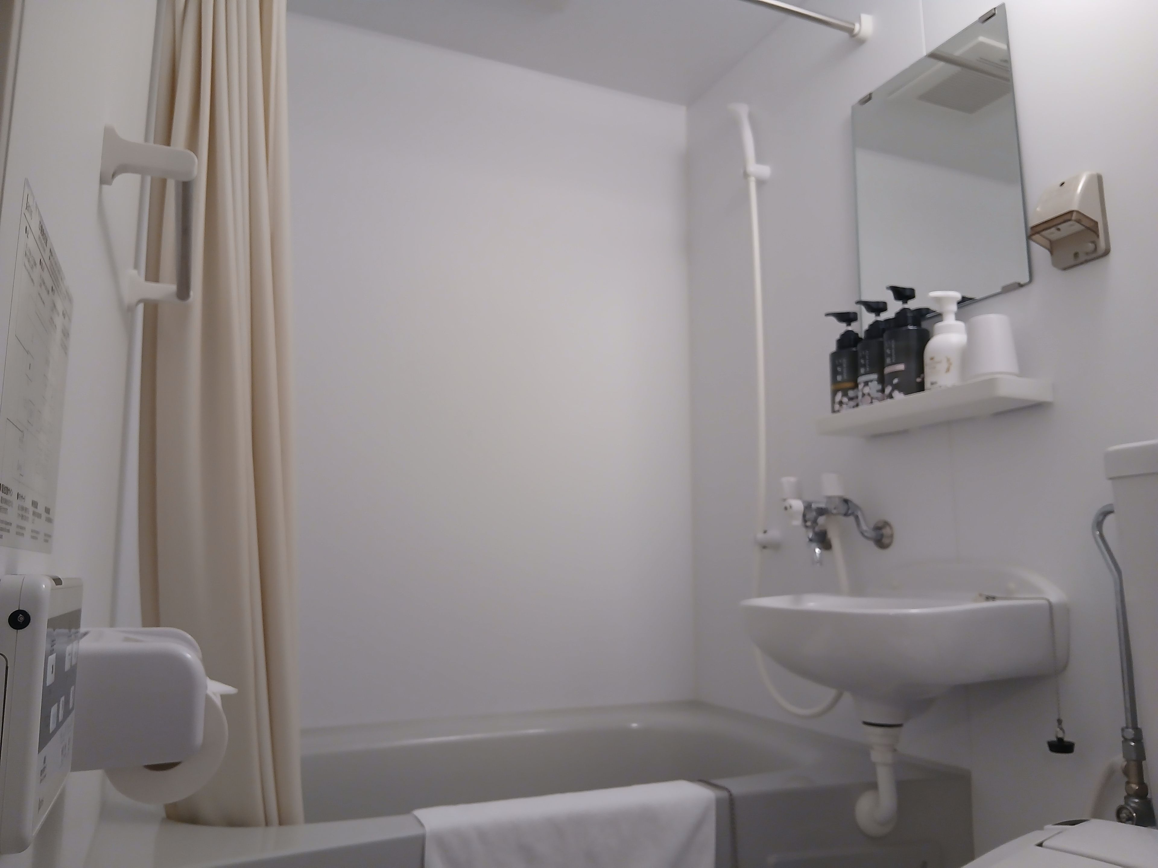 Un baño con una bañera, un lavamanos y un espejo.