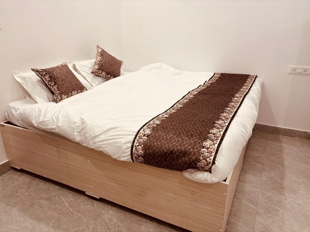 A bed with a wooden frame, white bedding, and decorative pillows.