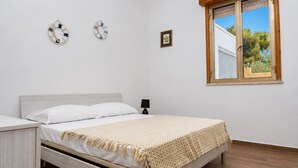 A bedroom with a bed, a nightstand, a window with a view, and wall decorations.