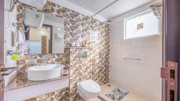 Un baño con lavamanos blanco, inodoro y zona de ducha.