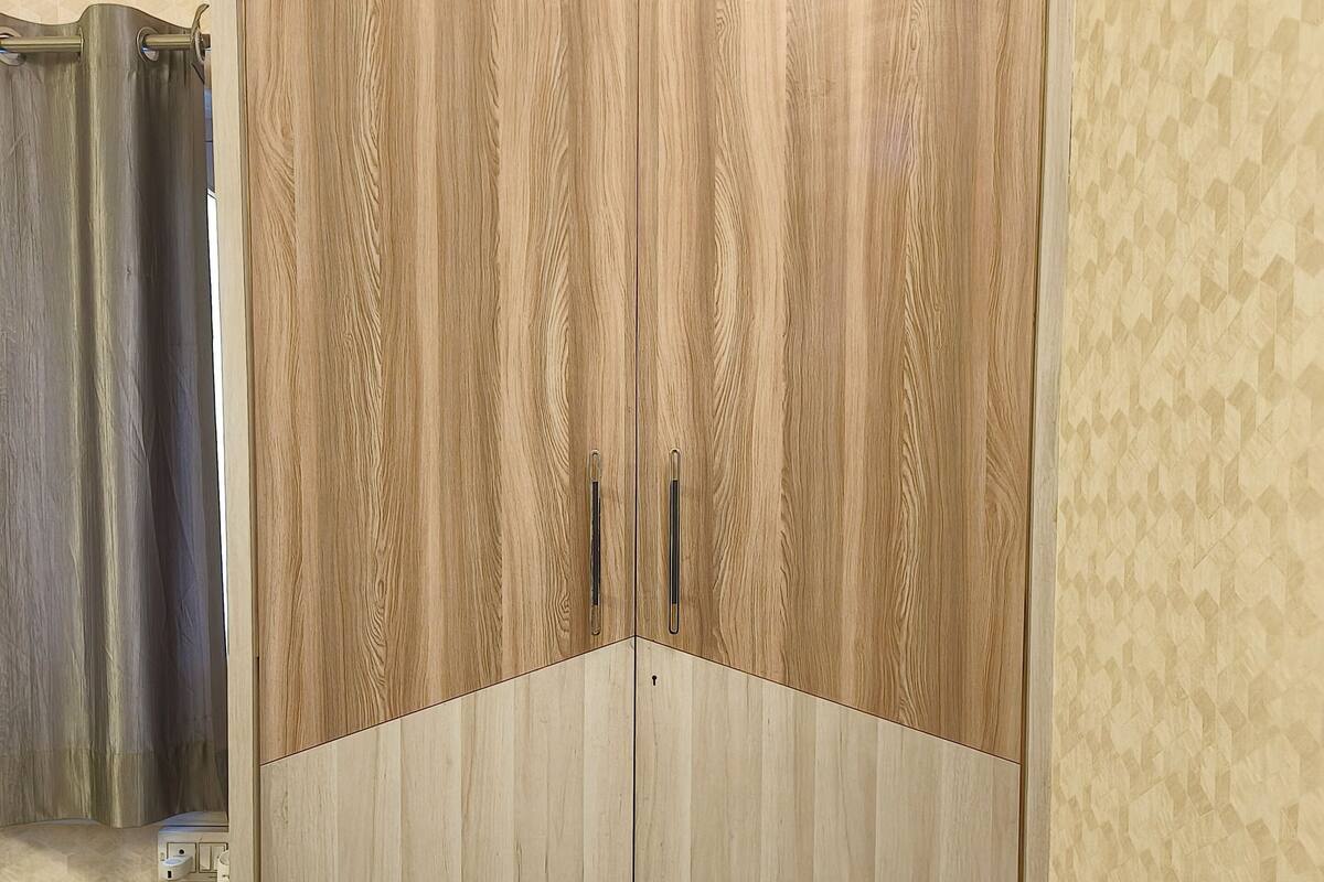 A wardrobe with a geometric pattern on the wall behind it.