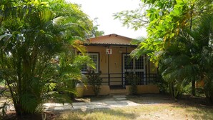 A building with a sign indicating room number 1, surrounded by lush greenery.