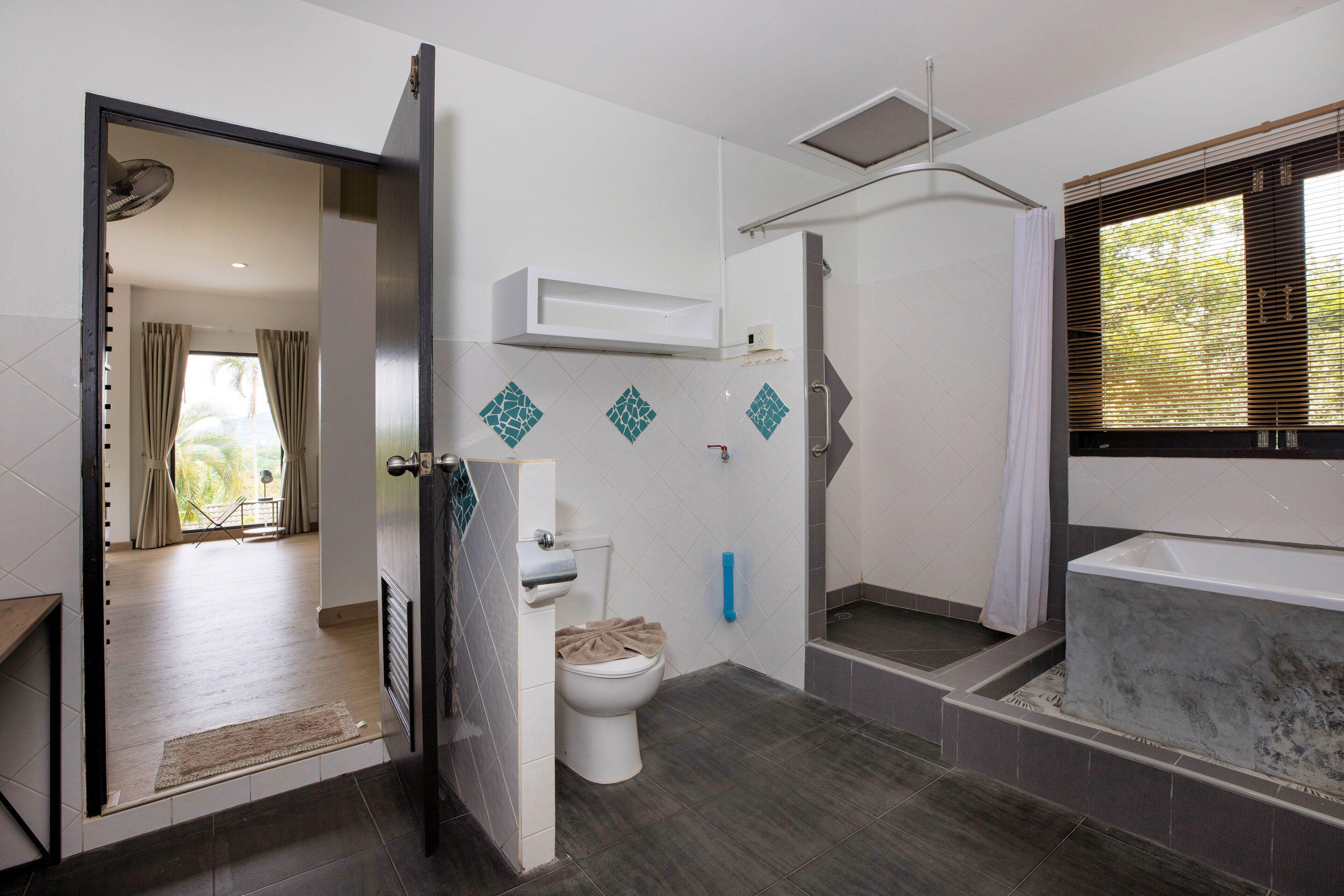 A modern bathroom with a shower, toilet, and bathtub.