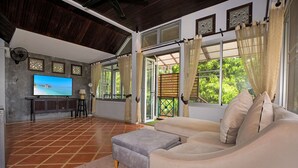 A spacious living area with a large flat-screen TV, a comfortable sofa, and a coffee table.