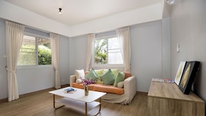 A modern living room with a sofa, coffee table, and artwork on a wooden console.