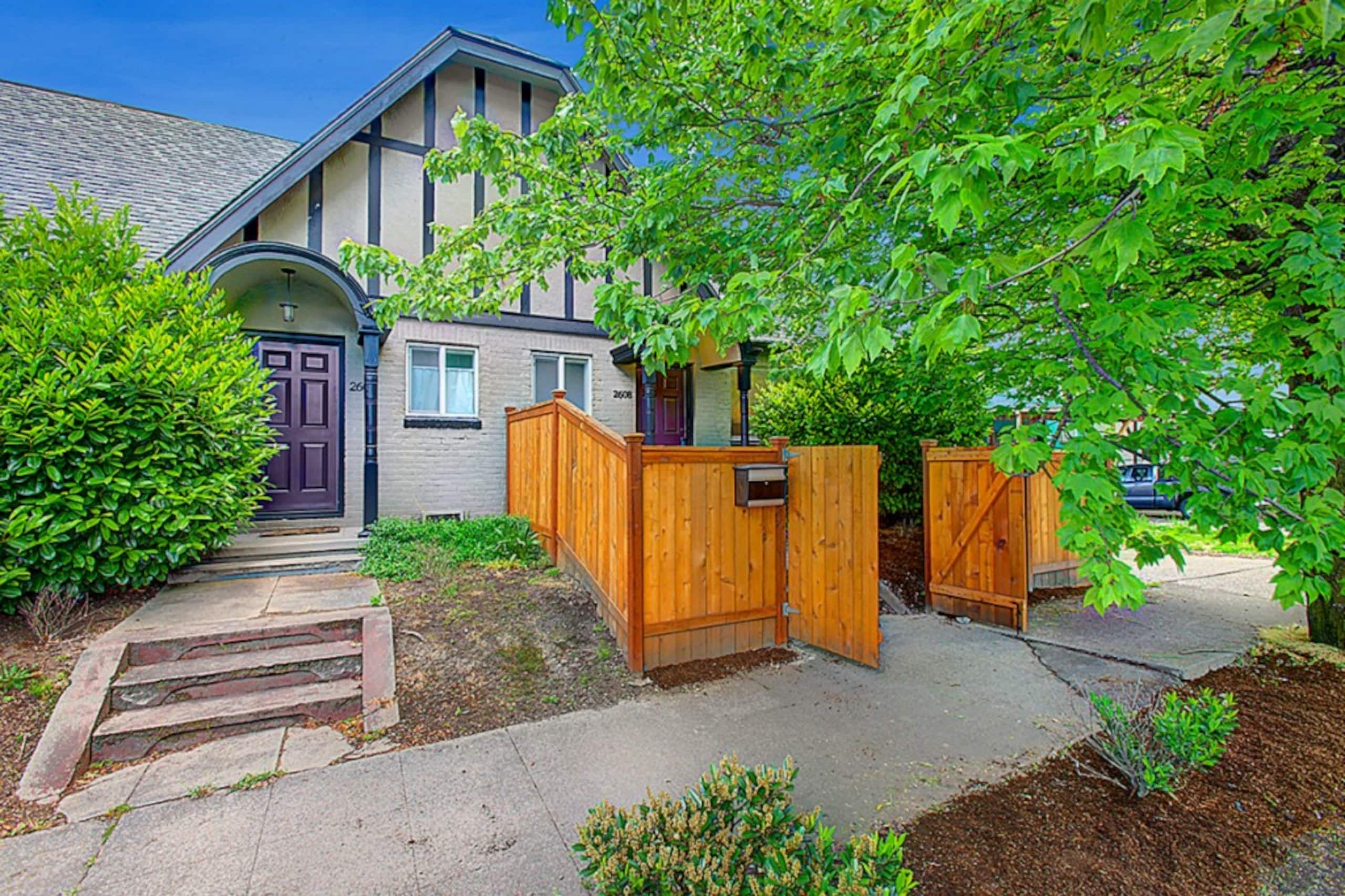 A residential house with a front yard, a wooden gate, and a mailbox.