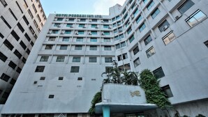 A multi-story hotel with a modern architectural design, featuring numerous windows and air conditioning units. - Hotel Purbani International Limited (Dhaka)