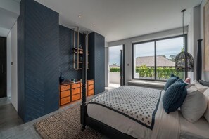 A modern bedroom with a large bed, a built-in wardrobe, and a view of the outdoors through a large window. - Mandala Oasis (Canggu)