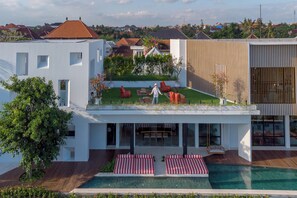 A modern house with a rooftop garden, a swimming pool, and a dining area with outdoor seating. - Mandala Oasis (Canggu)