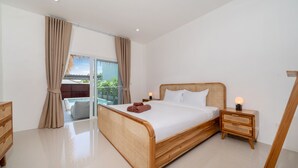 A modern bedroom with a large bed, wooden headboard, and a nightstand with a lamp. - Balinese-Style 2BR Pool Villa Aemy (Rawai)