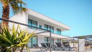 A modern building with a white facade, multiple balconies, and sun loungers. - Sunset Serenity Villa With Pool, Gym and Sauna (Kastela)