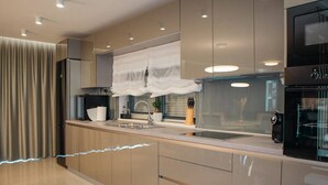 A modern kitchen with a stainless steel sink, a built-in oven, and a microwave. - Sunset Serenity Villa With Pool, Gym and Sauna (Kastela)