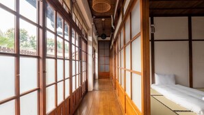 A traditional Japanese-style room with tatami flooring, sliding doors, and a bed with white bedding. - victory guesthouse (Pingtung)