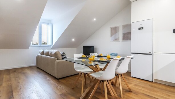 Un loft moderno con comedor, sofá y cocina.