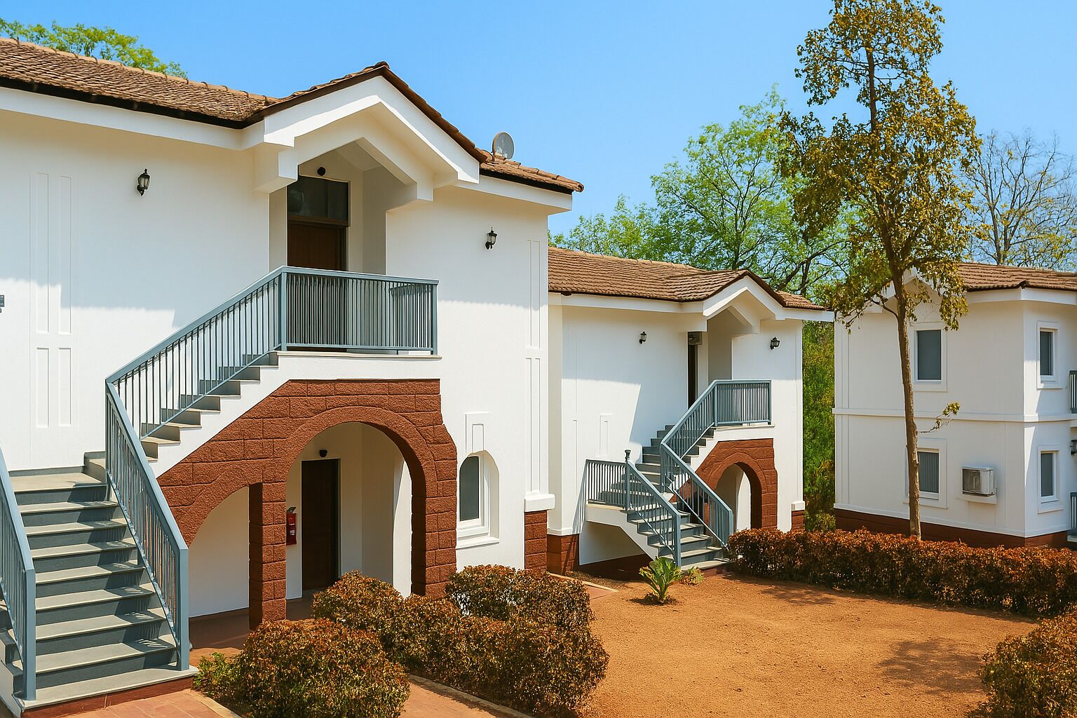 A building with a central staircase, a small balcony, and a brick archway.