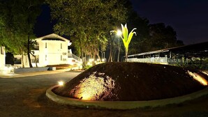 A landscaped area with a mound, a building, and a pathway. - Amritara Serenity (Sanguem)