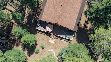 An aerial view of a building with a rooftop deck, surrounded by trees.