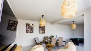 Een moderne woonkamer met een pooltafel, zachte zitplaatsen en kunstwerken aan de muren.
