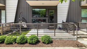 Un bâtiment moderne doté d’un balcon, d’une rambarde en métal et offrant une vue sur les environs.