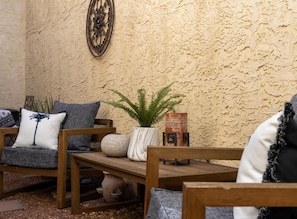 Un banco de madera con una planta en maceta, un adorno de pared y una maceta de piedra rústica.