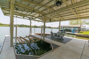 Un espace extérieur abrité avec une piscine, des sièges et une vue sur le lac.
