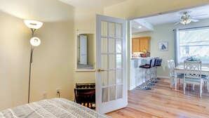 A room with a bed, a desk, a chair, a dining table with chairs, a ceiling fan, and a kitchen area visible through an open door. - 5 Mi to JetBlue Park: Condo w/ Pool & Pickleball (Fort Myers)