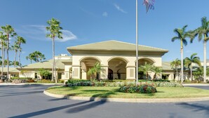 A hotel with a central building featuring arched entrances, surrounded by palm trees and a well-maintained lawn. - 5 Mi to JetBlue Park: Condo w/ Pool & Pickleball (Fort Myers)