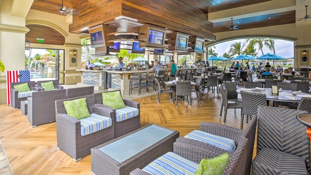 A spacious indoor area with multiple seating arrangements, including sofas and tables, and a bar area with televisions. - 5 Mi to JetBlue Park: Condo w/ Pool & Pickleball (Fort Myers)