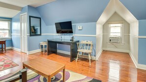 Una habitación con escritorio, silla y televisor.