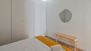A bedroom with a bed, a bench, a wardrobe, and a mirror. - Simple Life I, Setúbal (Setúbal)
