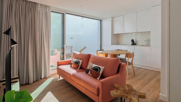 A modern living room with a sofa, a dining table, and a kitchen area. - Simple Life I, Setúbal (Setúbal)