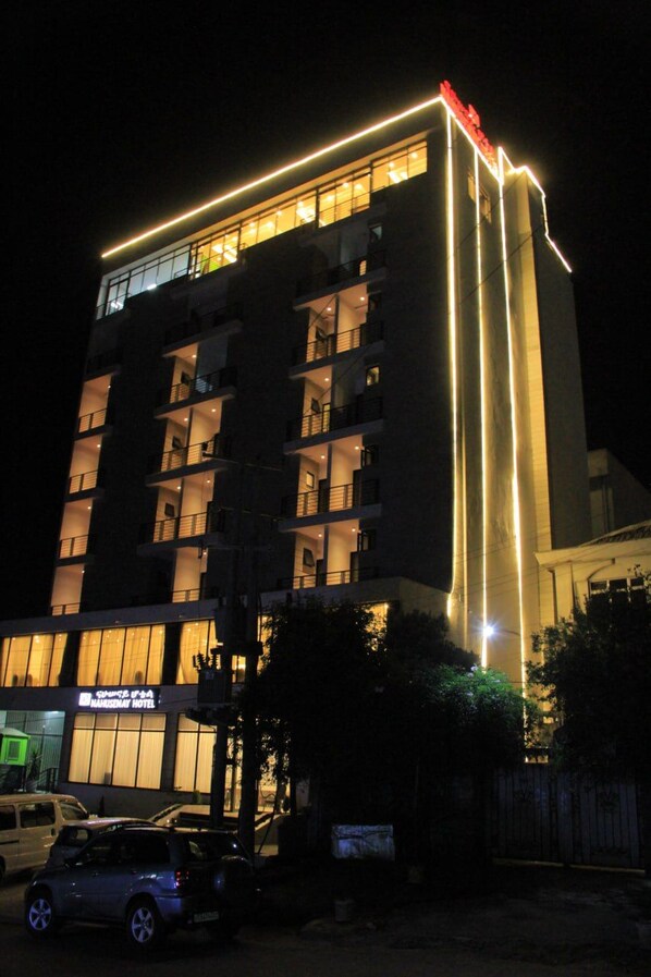 A multi-story hotel with illuminated signage and balconies.