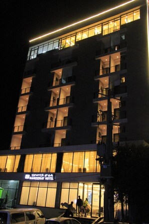 A multi-story hotel with balconies and a sign indicating it is the Nahusenay Hotel.