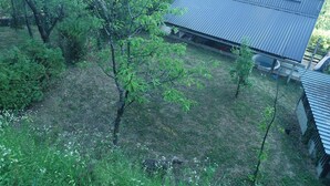 A residential area with a house featuring a corrugated metal roof and a small attached structure. - Plesivica Hillside Holiday Home With Hot -tub (Jastrebarsko)