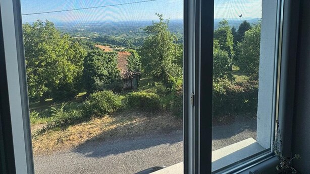 A view from a window overlooking a rural landscape with trees and a road. - Plesivica Hillside Holiday Home With Hot -tub (Jastrebarsko)