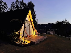 A triangular tent-like structure with a wooden deck and a single chair. - The Kamsha (Kintamani)