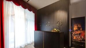 Un intérieur moderne avec un mur lambrissé en bois foncé, un comptoir d’accueil agrémenté d’un objet décoratif et une grande œuvre d’art encadrée sur le côté droit.