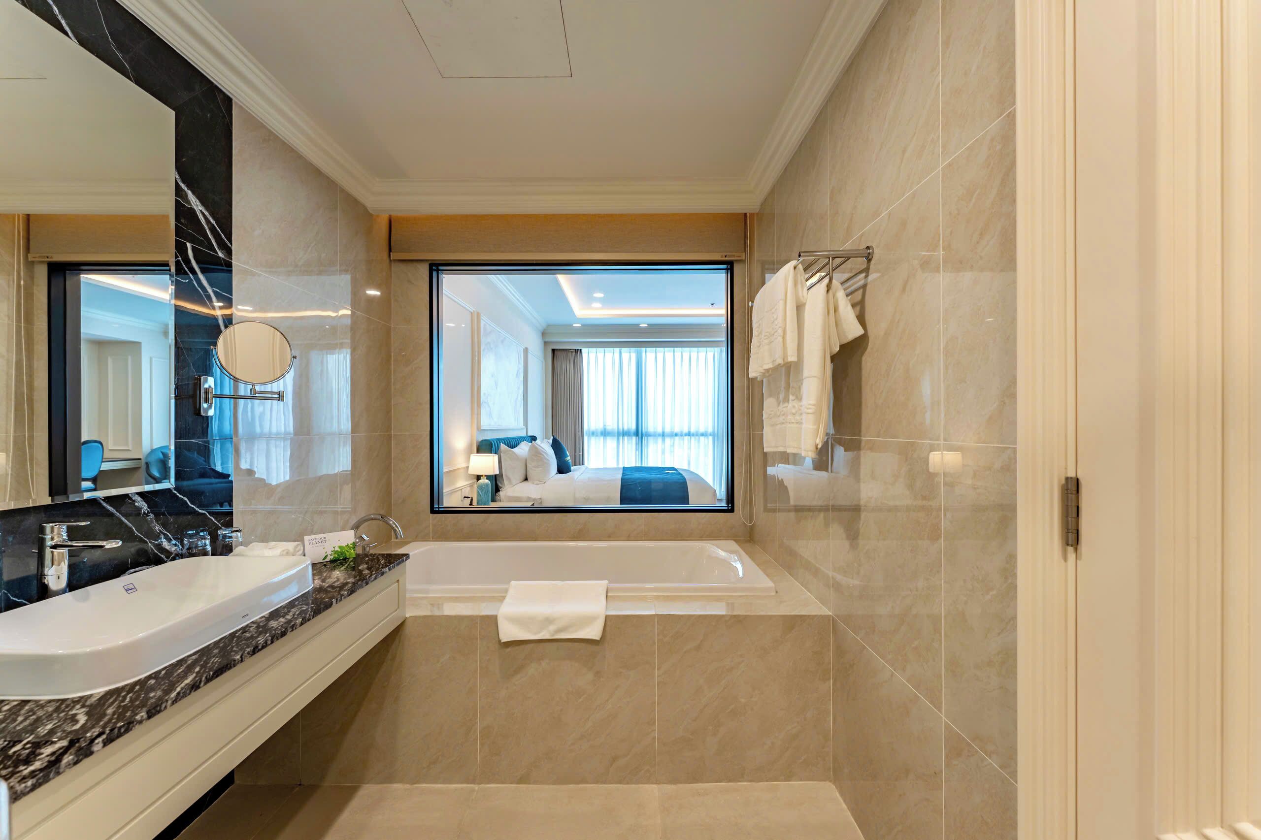Un baño moderno con un espejo grande, una bañera y un lavamanos.
