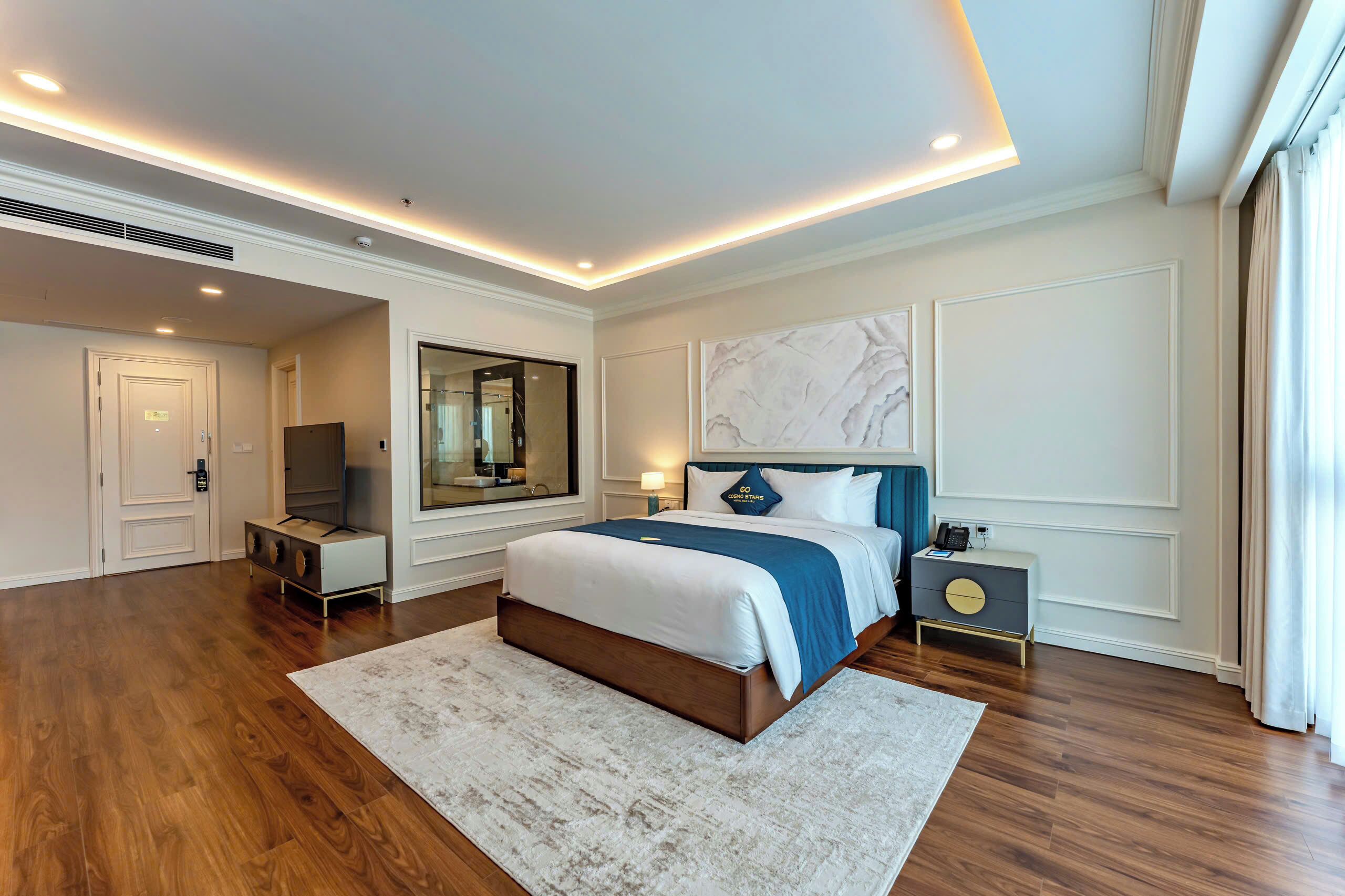 Un dormitorio moderno con una cama grande, un televisor y una mesita de noche.