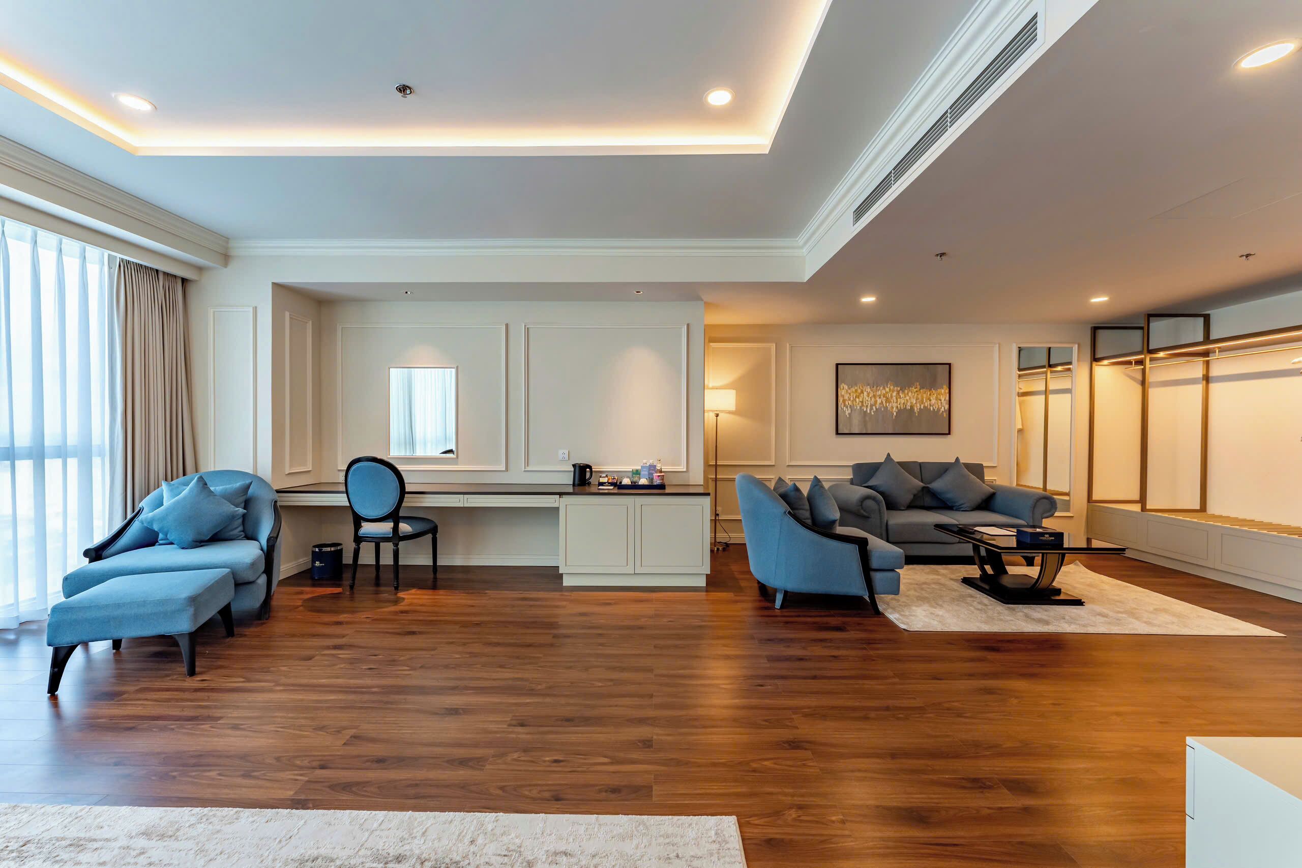 A spacious living area with a wooden floor, a sofa, a chair, and a coffee table.