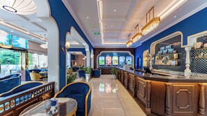 A modern hotel lobby with a bar area, seating, and a view of the restaurant. - Cosmo Stars Hotel Bac Lieu (Bac Lieu)