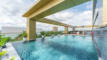 Alberca al aire libre, sombrillas en la alberca y camastros