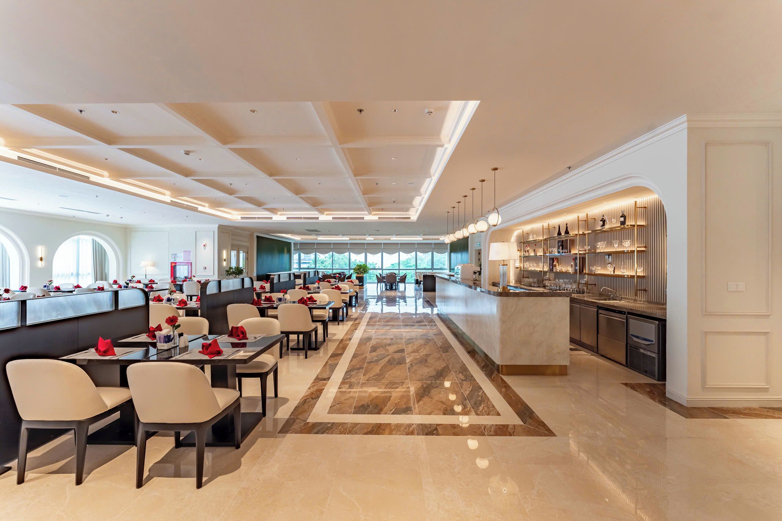 Un hall d’hôtel spacieux avec un espace salon central, un bar et un comptoir d’accueil.