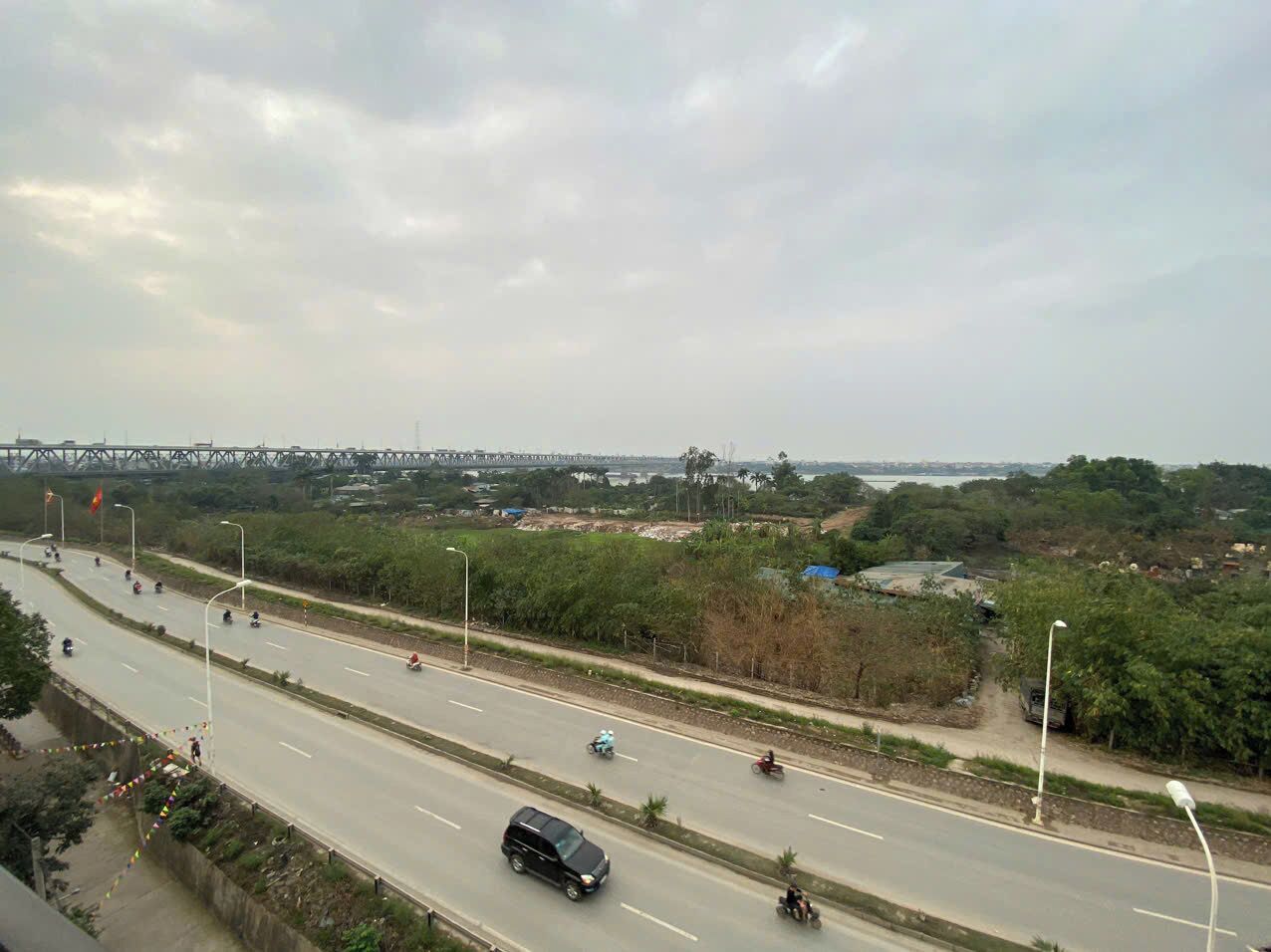 A multi-lane highway with vehicles, a pedestrian walkway, and a bridge in the background.