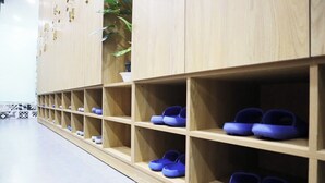 Reihe von Holzsohlenschränken mit blauen Schuhen.